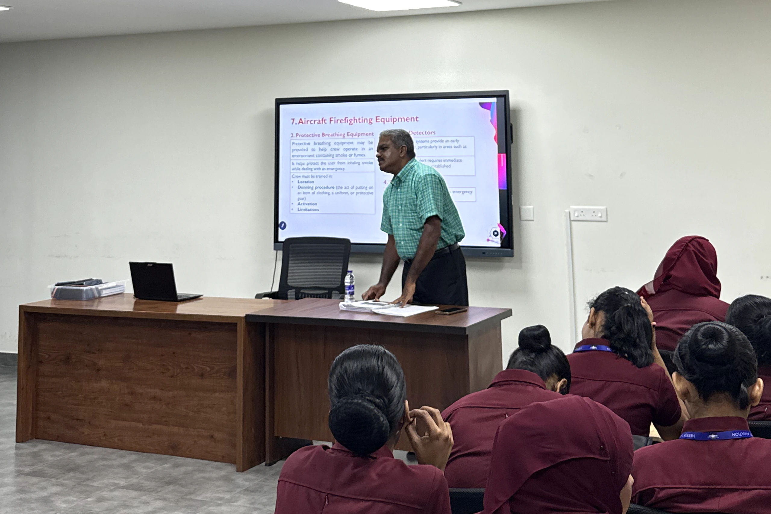 A trainer teaching a class of uniformed students in a Neerja classroom