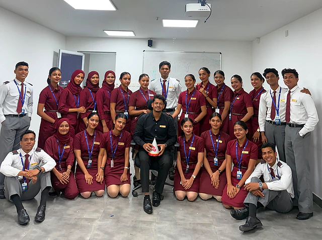 A batch of Neerja School of Aviation students in uniform with their trainer in a classroom