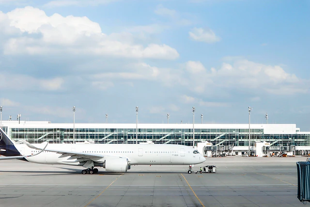 A wide-body aircraft parked in front of an airport terminal