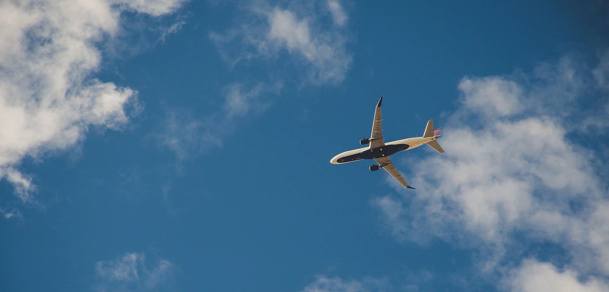 A passenger jet flying through a blue sky with white clouds