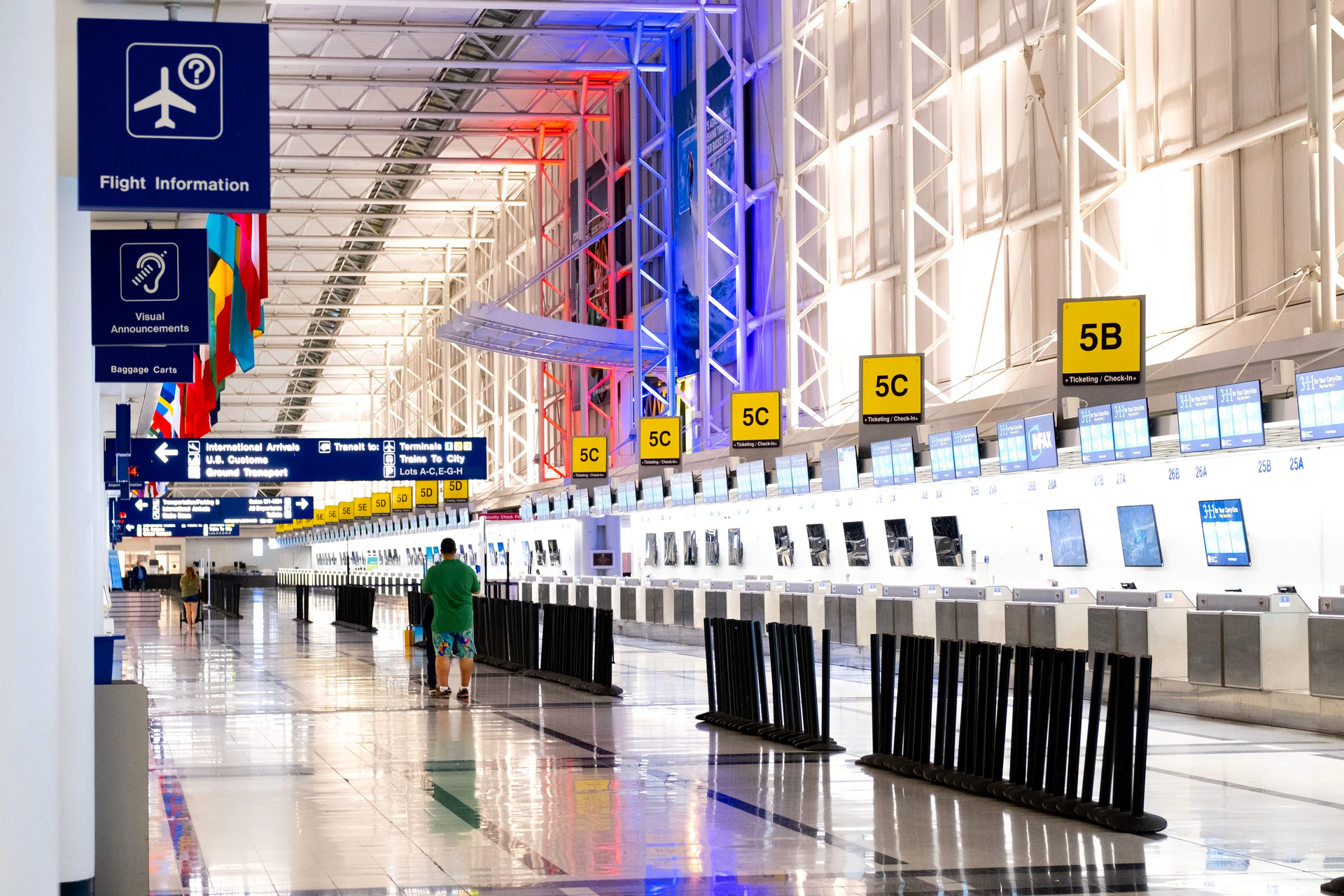 Check-in desks along a bright airport departure hall
