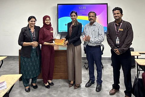 A student receiving an award from staff in a classroom